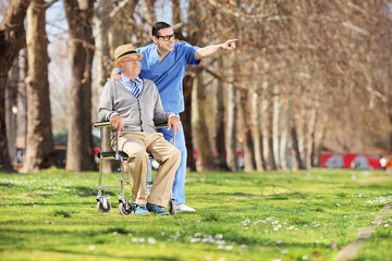 Poster - Male nurse showing something to a man in wheelchair