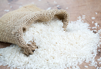 Wall Mural - rice in a burlap bag on wooden surface