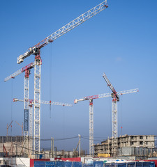 construction cranes on a blue sky background