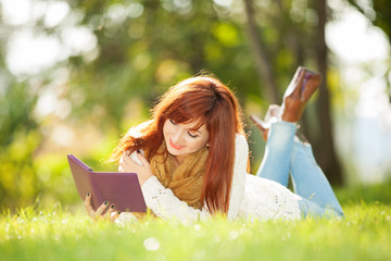 Young pretty woman with tablet in the park