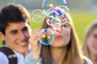 © nenetus - Couple having fun with soap bubbles in the park