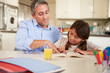 © Monkey Business - Father Helping Daughter With Reading Homework At Table