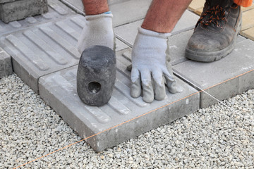 Wall Mural - Worker installing concrete brick pavement, using hammer