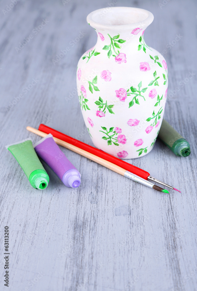 Beautiful hand made vase and art materials on wooden table