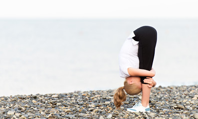 Wall Mural - woman doing yoga and sport exercises on  beach