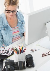 Wall Mural - Blonde photographer looking over contact sheet at her desk