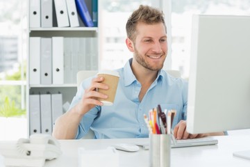 Sticker - Smiling man working at his desk drinking a take away coffee