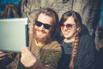 Wall Mural - young modern stylish couple using tablet urban