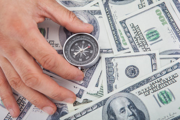 Hand Holding Compass On Us Currency