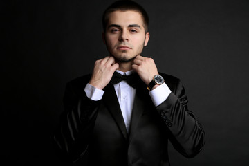 Canvas Print - Handsome young man in suit on dark background