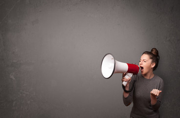 Canvas Print - Girl shouting into megaphone on copy space background