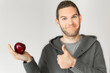 Young man holding an apple and thumb up