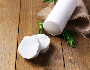 Sticker - Tasty bushe cheese with rosemary, on wooden table