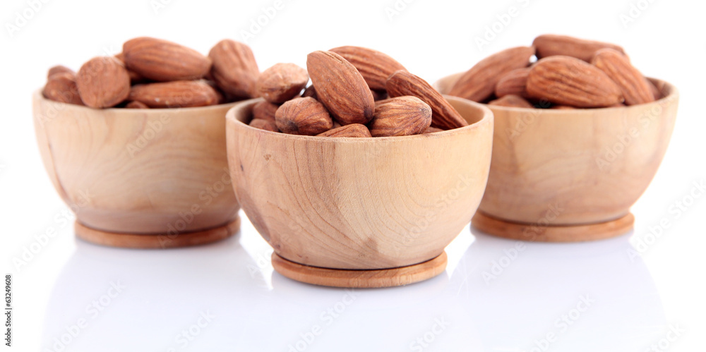 Almond in wooden bowls, isolated on white