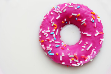 Wall Mural - donut coated with a pink frosting and sprinkles of different col