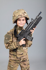 Wall Mural - Young boy dressed like a soldier with rifle