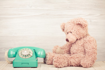 Fototapete - Teddy Bear near retro telephone