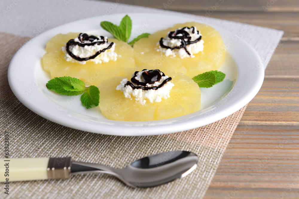 Tasty pineapple with cottage cheese on  wooden table