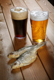 Fototapeta Boho - Two glasses of beer with dried fish on a table