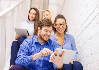 Poster - team with tablet pc computer sitting on staircase