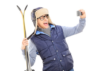 Poster - Man in winter clothes taking a selfie with skis