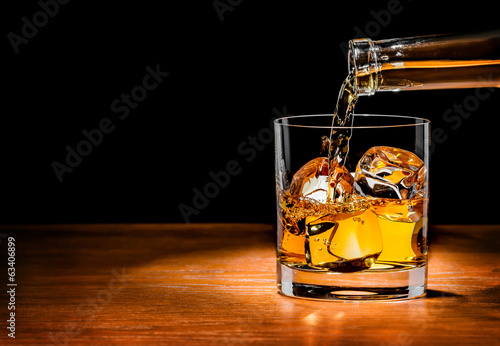 Fotografía Pouring whiskey drink into glass