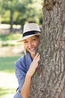 © WavebreakmediaMicro - Smiling woman hiding behind tree trunk