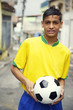 © lazyllama - Young Brazilian Football Player Holding Soccer Ball on Street