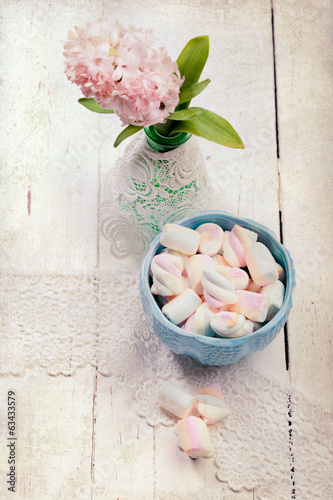 Tapeta ścienna Pastelowe kolorowe marshmallows i hiacynt kwiaty, na drewniane biurko