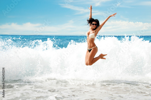 Photo Beautiful young girl jumping on sea