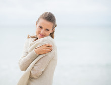 Portrait Of Happy Young Woman On Cold Beach