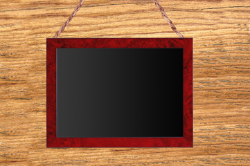 Small wooden framed blackboard on wooden background