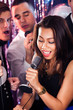 Woman Singing Into Microphone At Karaoke Party