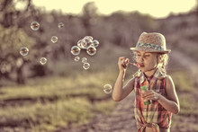 Carefree Girl Lets Soap Bubbles On A Warm Day