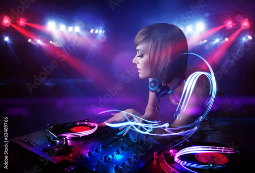 Board z aluminiowym obramowaniem Disc jockey girl odtwarzanie muzyki z efektami wiązki światła na scenie