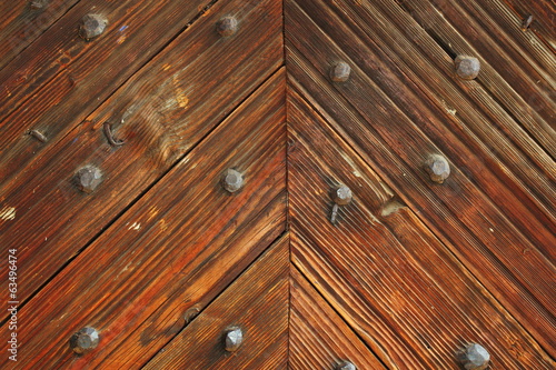 Board z aluminiowym obramowaniem Ciekawy wzór na drewnianych drzwiach