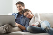 © stokkete - Couple relaxing on sofa with laptop
