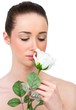 © WavebreakmediaMicro - Beautiful brunette smelling white rose