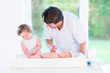 © famveldman - Adorable toddler girl helping her father to change a diaper