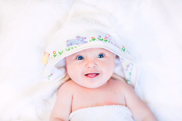 cute laughing baby in a hand made cross stitch hooded towel