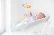 © famveldman - Cute newborn baby boy watching a colorful mobile toy