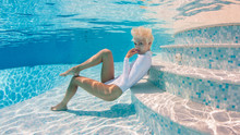 Woman Wearing Swimsuit Underwater In Swimming Pool.