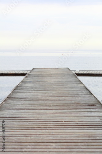 Board z aluminiowym obramowaniem Stare drewniane molo nad morzem