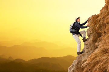 Female hiker climbing rocks.