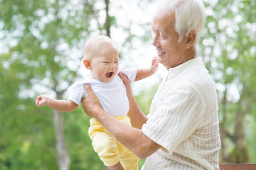 Asian grandfather playing with grandson