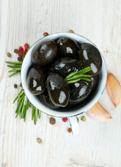 Wall Mural - black olives in a metallic cup on wooden surface