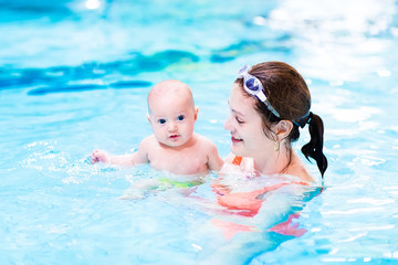 Wall Mural - Little baby enjoying swimming lesson in the pool with his mother