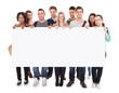 © Andrey Popov - College Students Displaying Blank Billboard