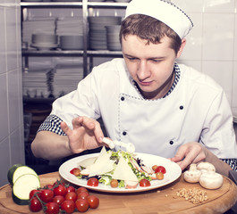 Wall Mural - chef preparing food in the kitchen at the restaurant