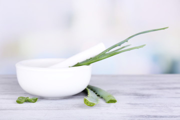 Canvas Print - Fresh green aloe leaves in wooden mortar  on wooden table